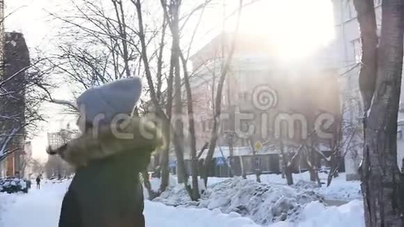 年轻漂亮的女人穿着热情的衣服在一个城市街道的背景下冬季日落慢动作视频的预览图