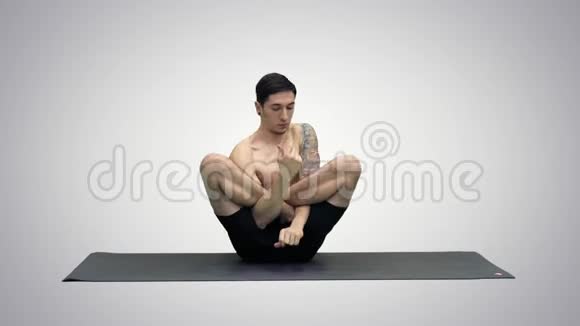 肌肉英俊的年轻人在锻炼瑜伽莲花手在脸上的梯度背景视频的预览图