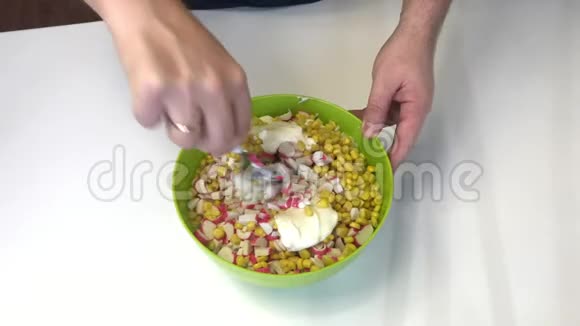 男人做沙拉将切碎的蟹条玉米北京卷心菜和蛋黄酱混合在容器中视频的预览图