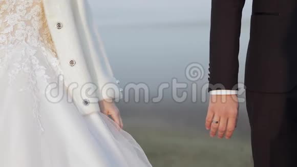 新婚夫妇的手白种人新郎和新娘在晨场雾婚礼视频的预览图