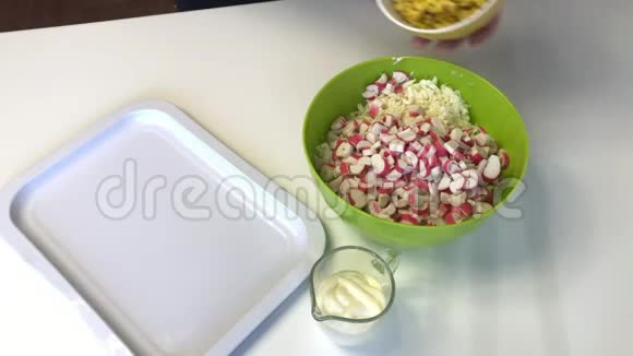 一个人做一份北京卷心菜沙拉混合切碎的卷心菜切碎的蟹条玉米和蛋黄酱视频的预览图