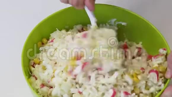 男人做沙拉用蟹棒玉米大白菜和蛋黄酱搅拌容器最后混合留下一个视频的预览图
