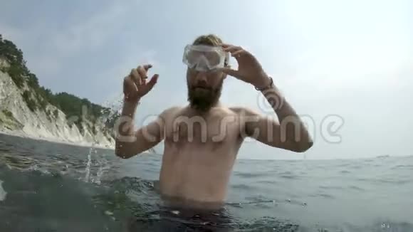 长着胡须的毛人腰深在水里脸上戴着面具特写视频的预览图