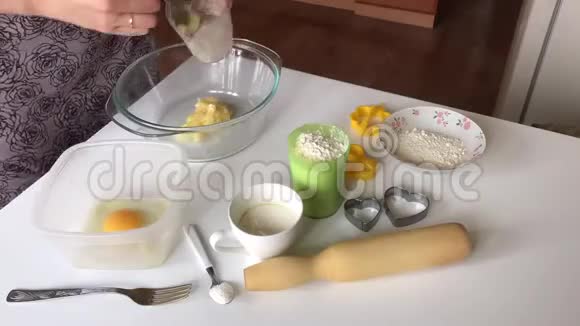 一个女人揉面卷面团把饼干空白放在锅里时间推移视频的预览图