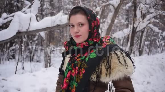 冬天森林里穿着俄罗斯传统服装的年轻女子慢动作视频的预览图