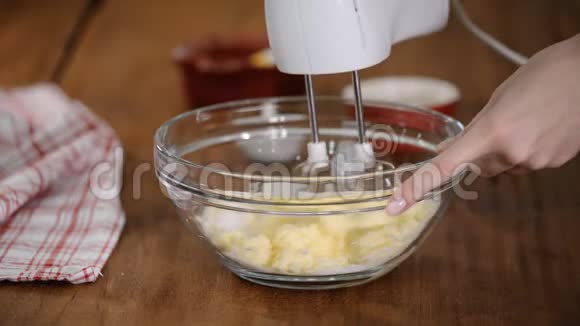将黄油与糖混合在玻璃碗中视频的预览图