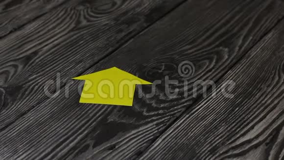在一张由刷过的木板制成的桌子上躺着一座用纸剪成的房子的轮廓一个男人把一串钥匙放在他身上视频的预览图