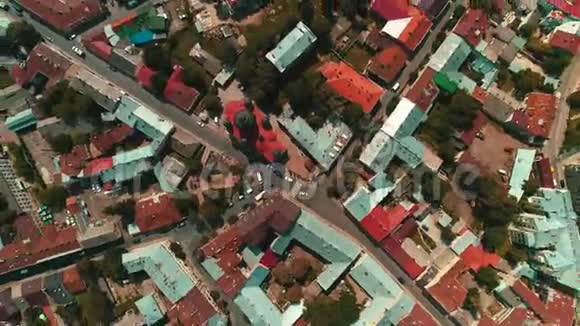 在一个阳光明媚的夏日镜头旋转城市景观中街道街区和房屋屋顶的空中镜头视频的预览图