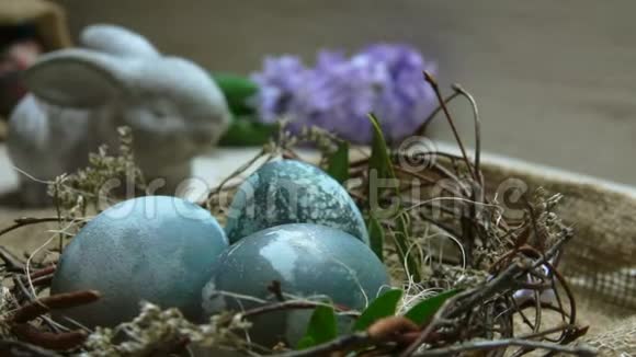 芙蓉茶染的复活节彩蛋在巢中的紫花背景视频的预览图