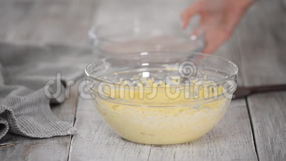 在面团中加入面粉厨师双手将干配料折叠到碗里的面团上视频的预览图