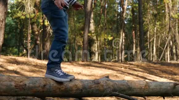 特写孩子腿一个小男孩走在原木上克服障碍幼儿发展运动室外视频的预览图