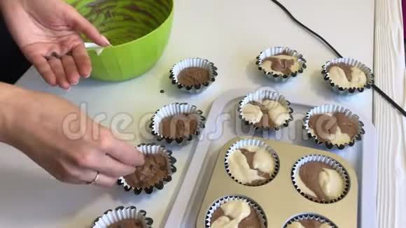 一个女人在蛋糕烤盘里把巧克力加入面团中做一个大理石蛋糕特写视频的预览图