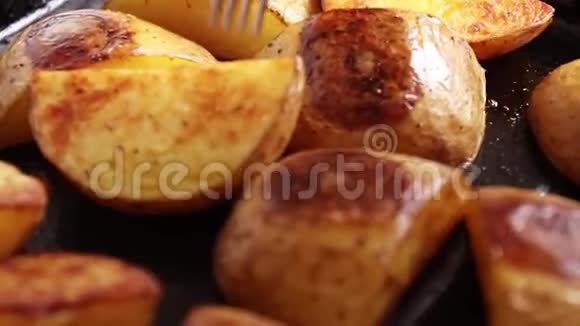 用香料和盐在带有叉子的金属锅上用烤土豆楔素土豆楔休闲食品餐视频的预览图