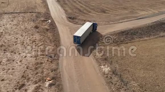 一辆大型卡车和一辆拖车沿着土路行驶在附近寻找掉头的地方视频的预览图
