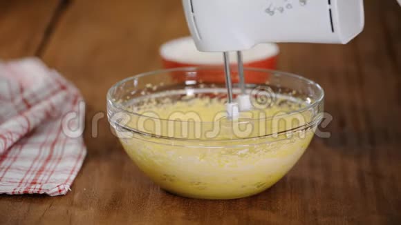 在面团中加入面粉将面团与马达搅拌器混合在碗中视频的预览图