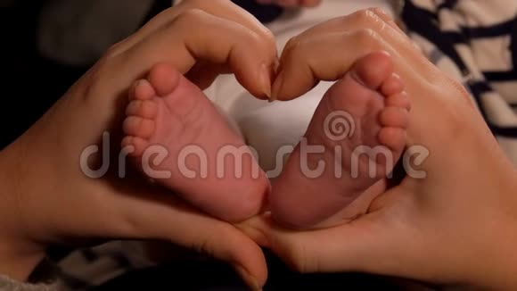 女性的双手正在做心脏姿势中间有一双可爱的小脚视频的预览图