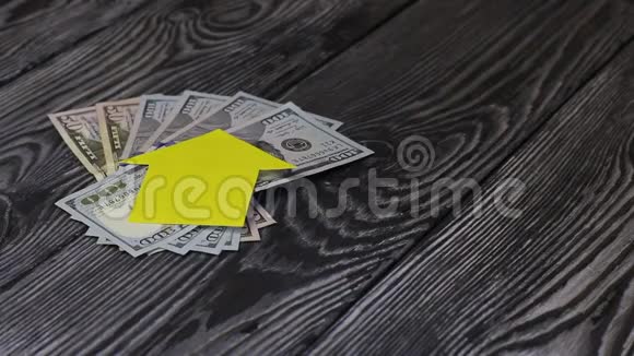 桌子上有一个美元迷房子的剪影从纸上剪下来就躺在上面一个男人把一串钥匙放在他身上视频的预览图