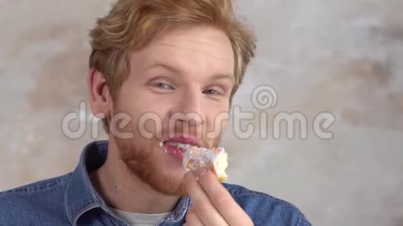红发男子被隔离在白色整理甜甜圈舔手指特写视频的预览图