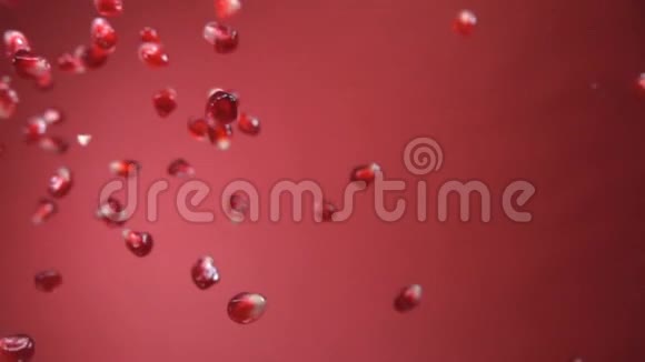 成熟石榴的多汁颗粒呈对角线落在红色的背景上视频的预览图