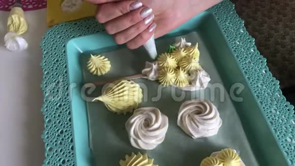 一个女人使用糕点袋和喷嘴将新的元素应用于新鲜的棉花糖托盘上摆着一个刚准备好的棉花糖视频的预览图