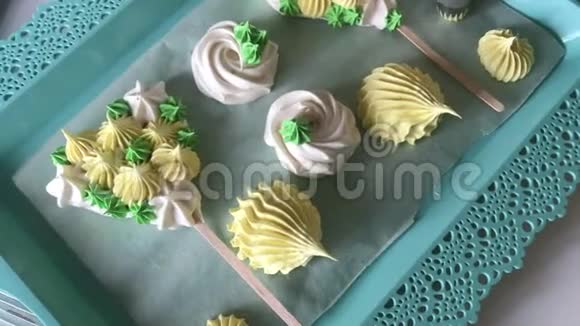 烹饪不同形状颜色和大小的棉花糖成品放在托盘上一个拿着糕点包的女人视频的预览图