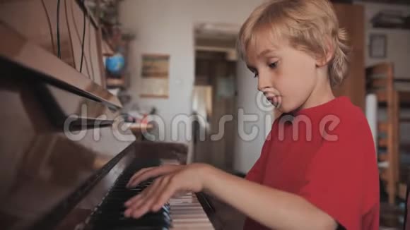 一个七岁的男孩在家弹钢琴视频的预览图