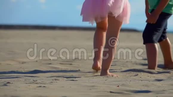 一个小男孩和小女孩在海滩上低角度地拍腿视频的预览图
