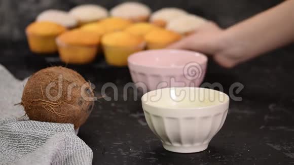 女人把松饼浸在液体白巧克力和椰子薄片中视频的预览图