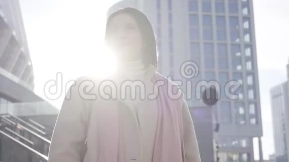镜头接近迷人的白种人女人站在阳光下微笑美丽的黑发女士站在视频的预览图