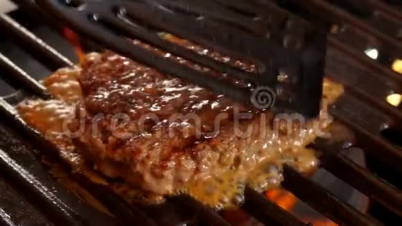 汉堡牛肉切块用铲子压在烤架上视频的预览图