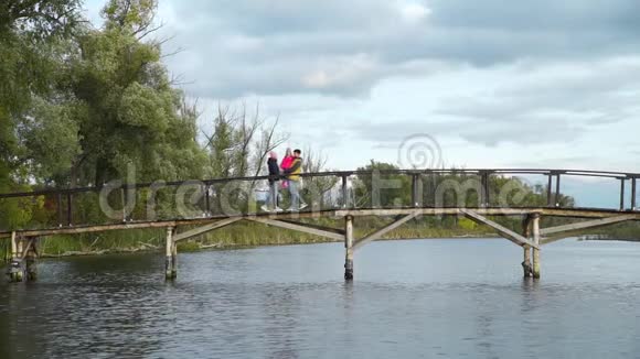 一家人走在秋日的木桥上视频的预览图