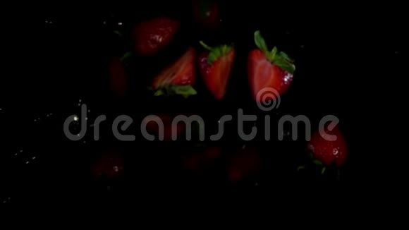 草莓在黑色的背景上随着溅出的水飞扬起来视频的预览图