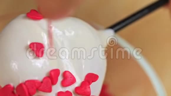 一个女人用红色的衣服洒上心蛋糕然后关上视频的预览图