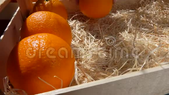 在一个阳光明媚的日子里多汁的橘子放在一个木箱里视频的预览图