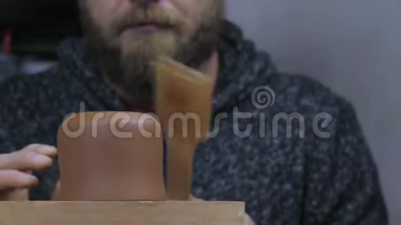 胡子师傅用特制的木铲为陶土茶壶做模具手工泥茶壶宜兴为茶道视频的预览图