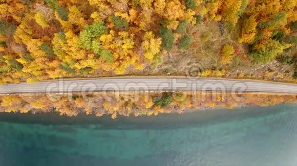 无人机在秋天飞越一条空荡荡的海岸公路空中垂直射击视频的预览图