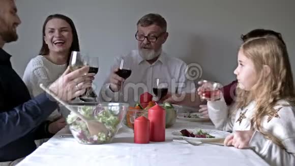 幸福的年轻家庭坐在节日的餐桌旁吃传统的感恩节食物视频的预览图