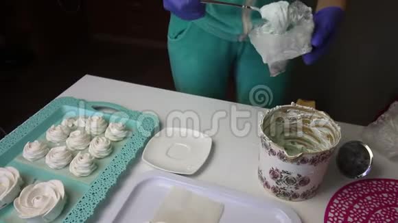 一个女人把棉花糖放在糕点袋里把空容器放在一边旁边的托盘上有一个棉花糖视频的预览图