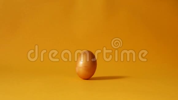 鸡黄金复活节彩蛋在黄色背景下旋转视频的预览图