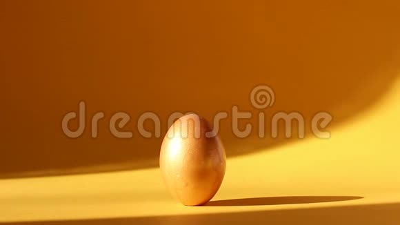 黄色背景阳光下的金色复活节彩蛋视频的预览图