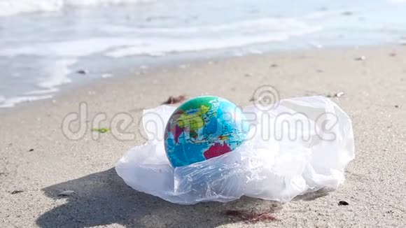 生态灾害概念阳光明媚的一天海边一个塑料袋里装着全球球视频的预览图