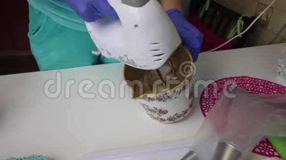 一个女人用搅拌器将果酱和蛋清搅拌在容器里为了得到棉花糖视频的预览图
