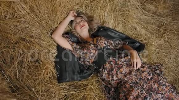 性感女人躺在干草堆上懒洋洋地转过头和手视频的预览图