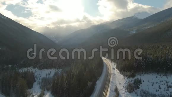 加拿大山景之间山谷中一条风景优美的公路的鸟瞰图视频的预览图