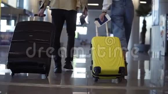 一对旅行者正在携带他们的行李和护照从候机厅走过后景人们是视频的预览图