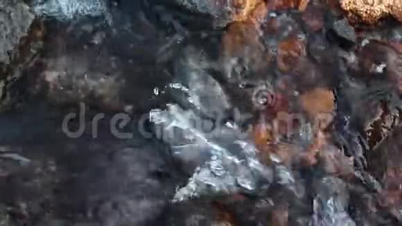 快河流在岩石上巨大的灰色和红色宝石俯视视频的预览图