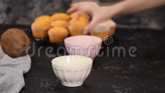 女人把松饼浸在液体白巧克力和椰子薄片中视频的预览图