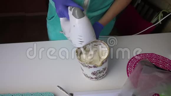 一个女人用搅拌机在容器里准备棉花糖视频的预览图