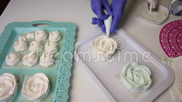 呈玫瑰状的棉花糖在托盘上形成经典形状一个女人用糕点包和喷嘴视频的预览图
