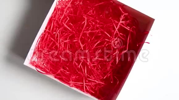 女人的手把鹌鹑蛋放在白色桌子上带有红色装饰的盒子里视频的预览图